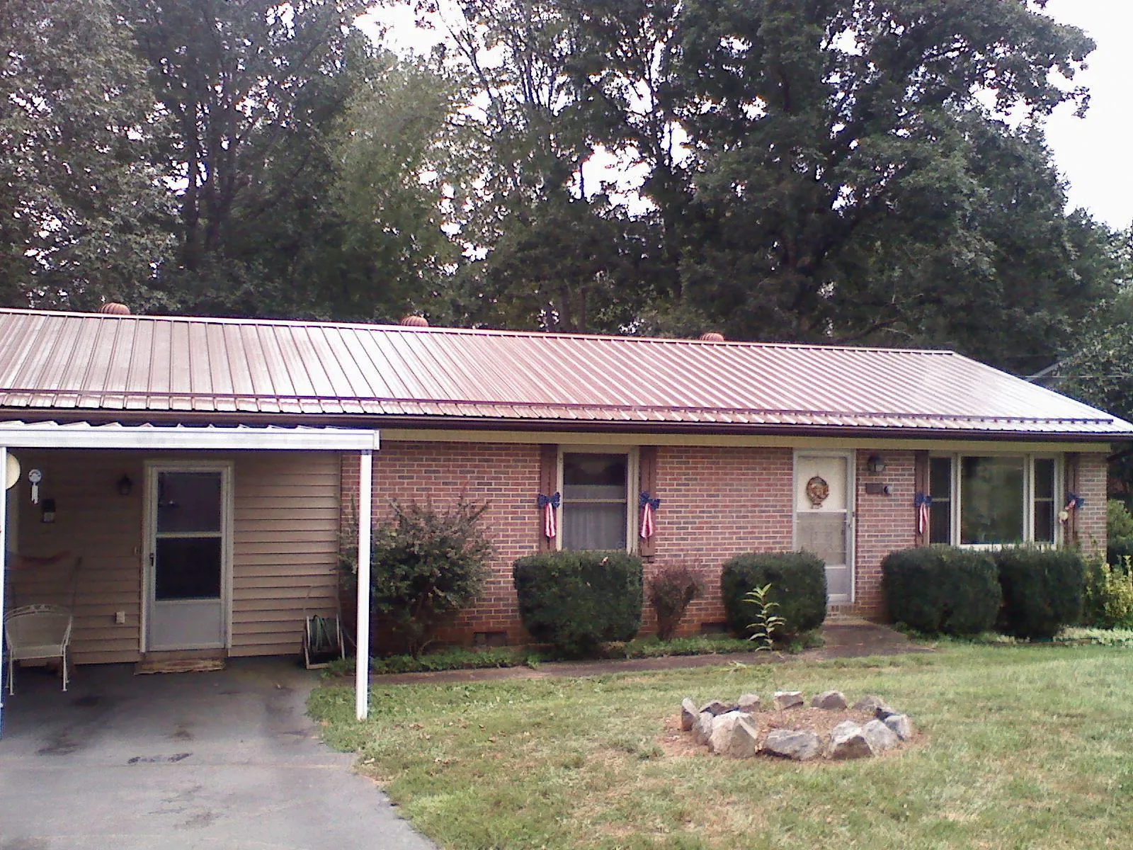 Bronze metal roof and carport on a brick ranch home — Roof Repair work by our crew in Perrysburg